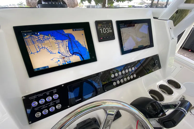 Slide: The Image of Control panel of a 2015 Edgewater 320CC boat with navigation screens and controls. - 31