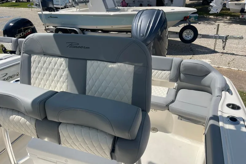 Slide: The Image of 2026 Pioneer 202 Islander boat interior with gray and white cushioned seating. - 14
