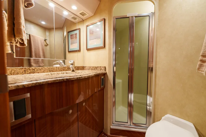 Slide: The Image of Luxurious bathroom in a 2008 Viking 68 Skybridge yacht with granite countertop and glass shower. - 33