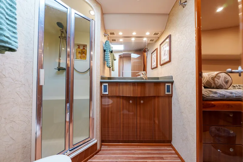 Slide: The Image of Luxurious bathroom in a 2008 Viking 68 Skybridge yacht with wooden cabinetry and glass shower. - 40