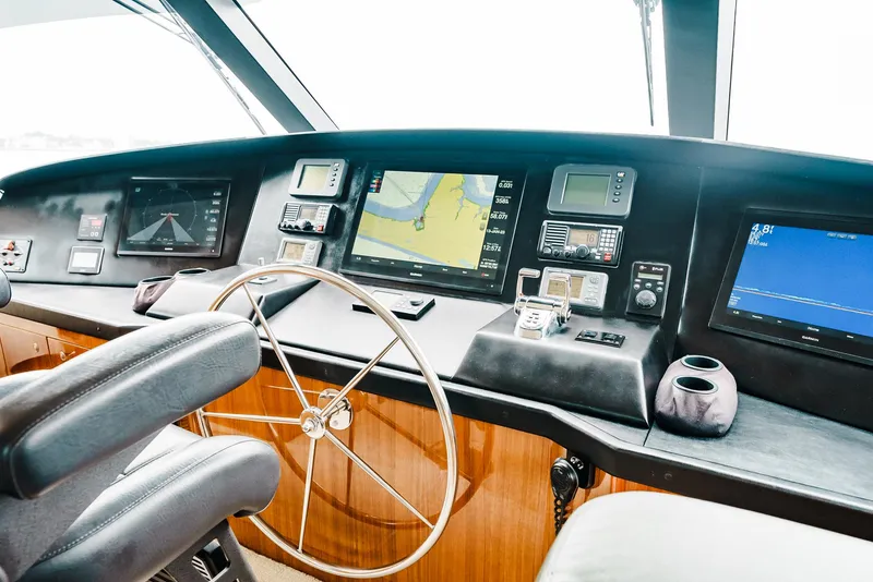 Slide: The Image of 2008 Viking 68 Skybridge yacht helm with navigation screens and steering wheel. - 43