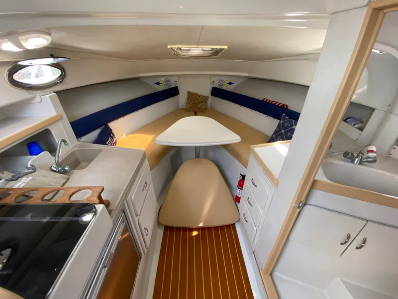 Slide: The Image of 1997 Stamas 310 Express cabin interior with kitchenette, dining area, and sink. - 14