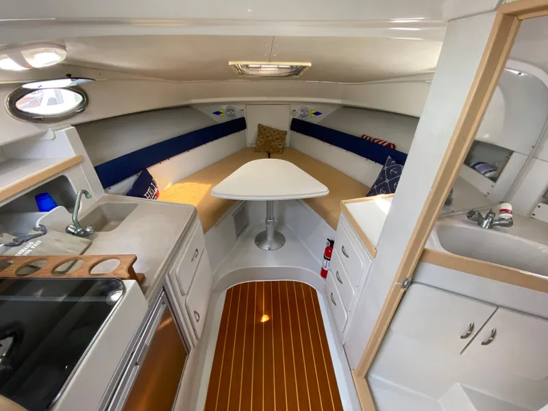 Slide: The Image of 1997 Stamas 310 Express cabin interior with kitchenette, dining area, and wood flooring. - 15