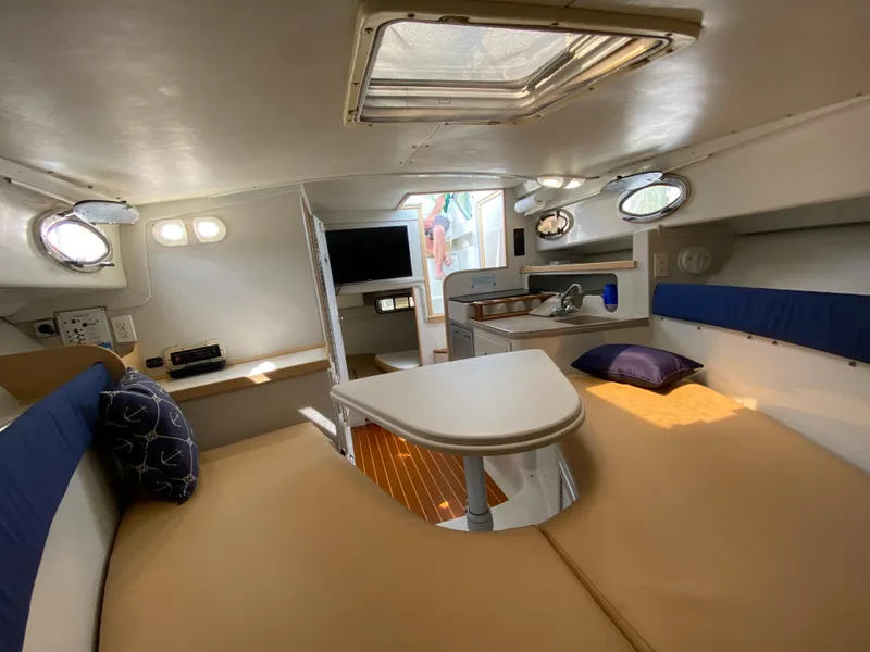 Slide: The Image of 1997 Stamas 310 Express cabin interior with seating, table, and portholes. - 16