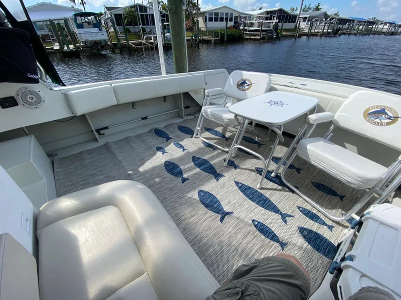 Slide: The Image of 1997 Stamas 310 Express boat interior with seating and table, docked by the water. - 3