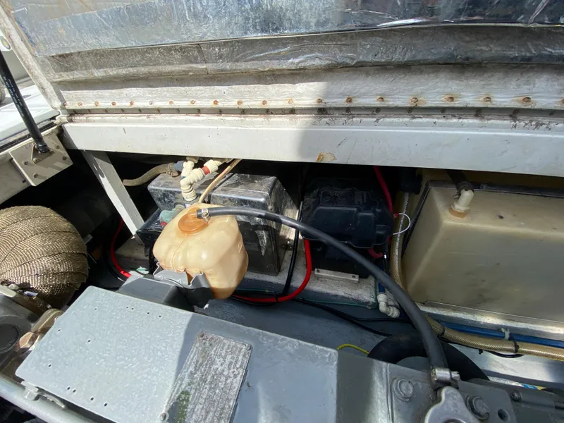 Slide: The Image of 1997 Stamas 310 Express engine compartment with battery and coolant reservoir. - 31