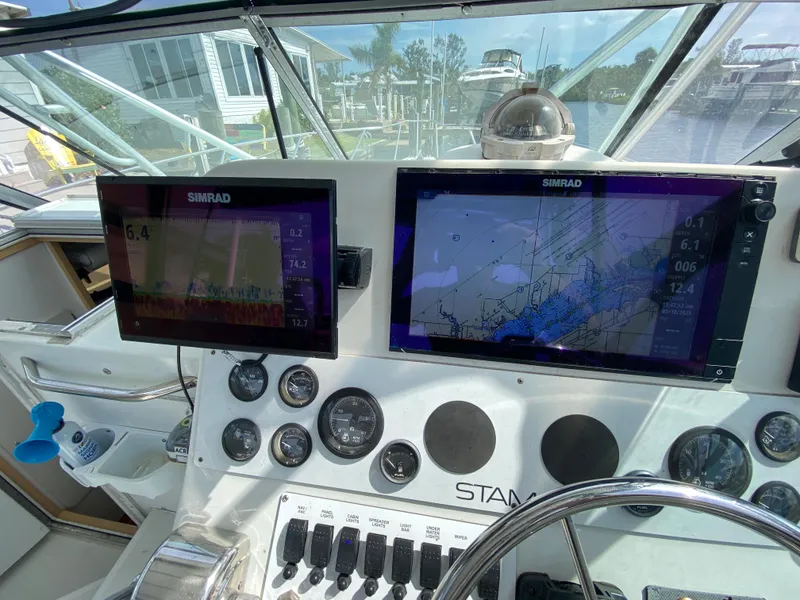 Slide: The Image of 1997 Stamas 310 Express helm with Simrad navigation displays and gauges. - 32