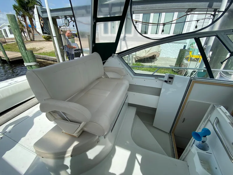 Slide: The Image of 1997 Stamas 310 Express boat interior with white seating and helm station. - 34