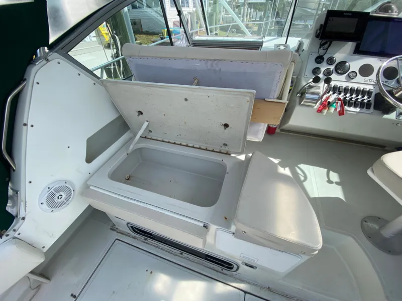 Slide: The Image of 1997 Stamas 310 Express boat interior with open storage compartment and control panel. - 35