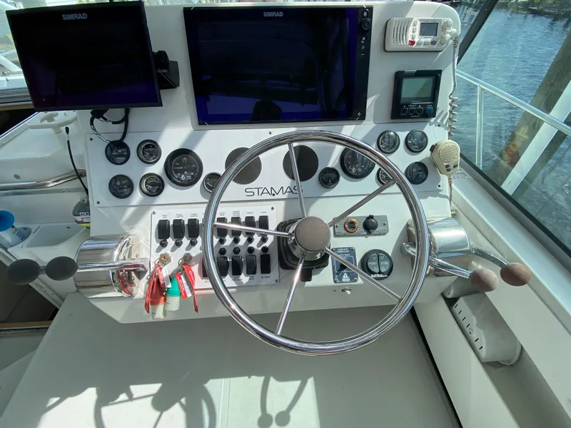 Slide: The Image of 1997 Stamas 310 Express boat helm with steering wheel, gauges, and navigation screens. - 41