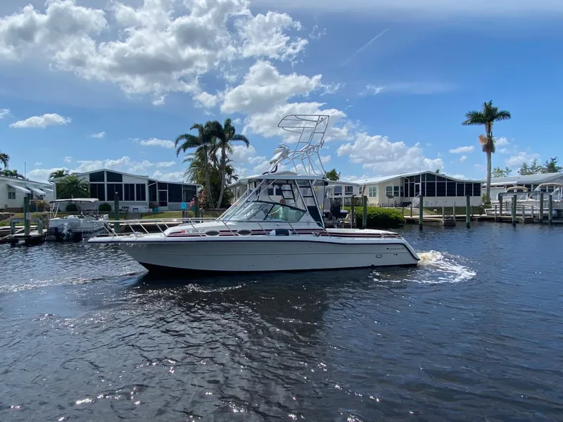 Slide: The Image of 1997 Stamas 310 Express boat cruising on a sunny day in a residential canal. - 44