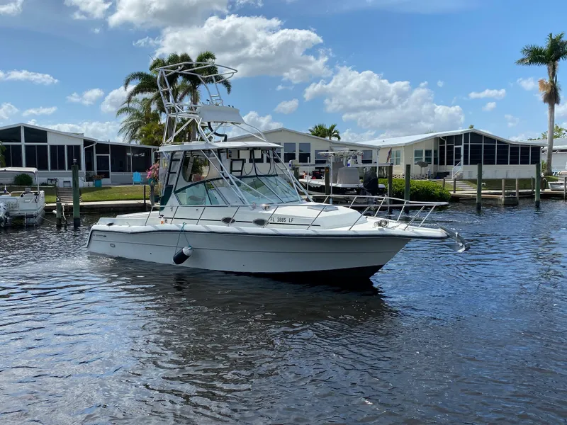 Slide: The Image of 1997 Stamas 310 Express boat on calm water near residential docks. - 46