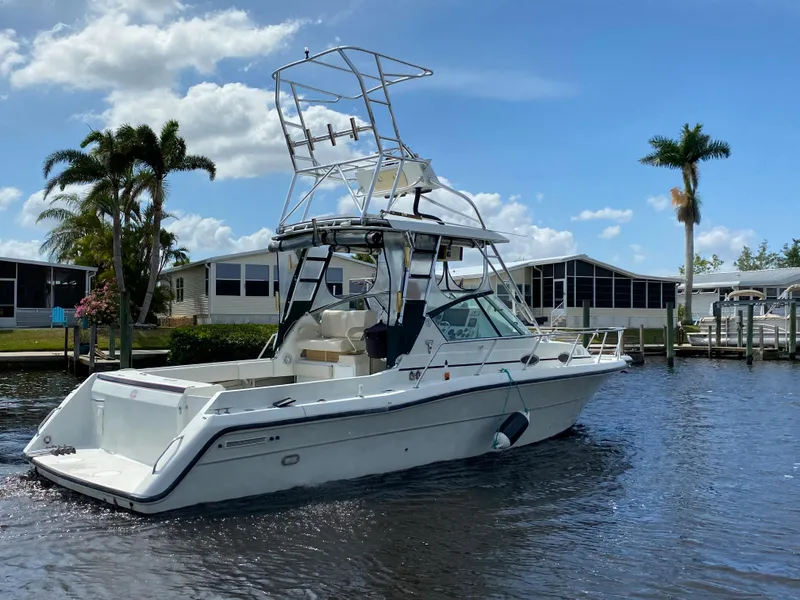 Slide: The Image of 1997 Stamas 310 Express boat cruising on a sunny day near waterfront homes. - 48