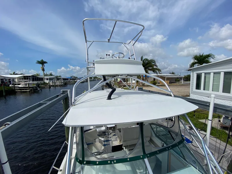 Slide: The Image of 1997 Stamas 310 Express boat docked at a marina with clear skies. - 6