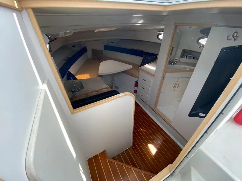 Slide: The Image of 1997 Stamas 310 Express cabin interior with wooden flooring, kitchenette, and seating area. - 9
