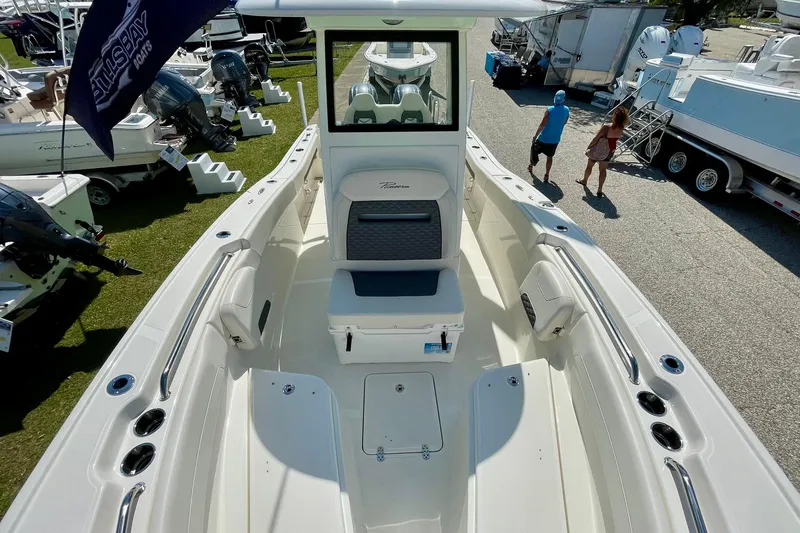 Slide: The Image of 2026 Pioneer 250 Pelagic boat interior with seating and storage, displayed at a boat show. - 6