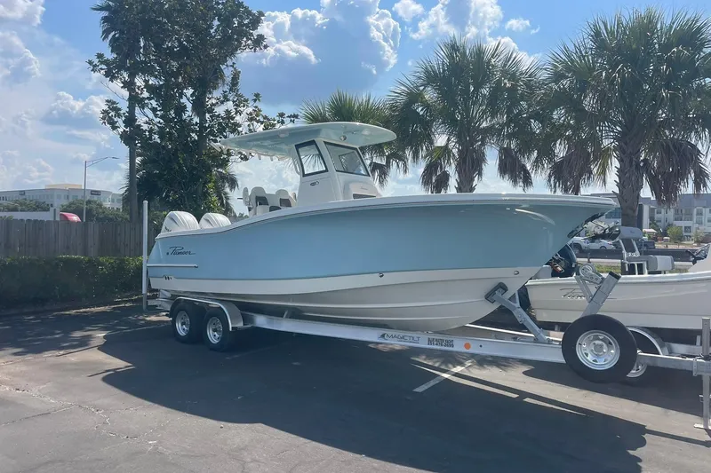 Slide: The Image of 2026 Pioneer 250 Pelagic boat on trailer, parked under palm trees in sunny weather. - 1