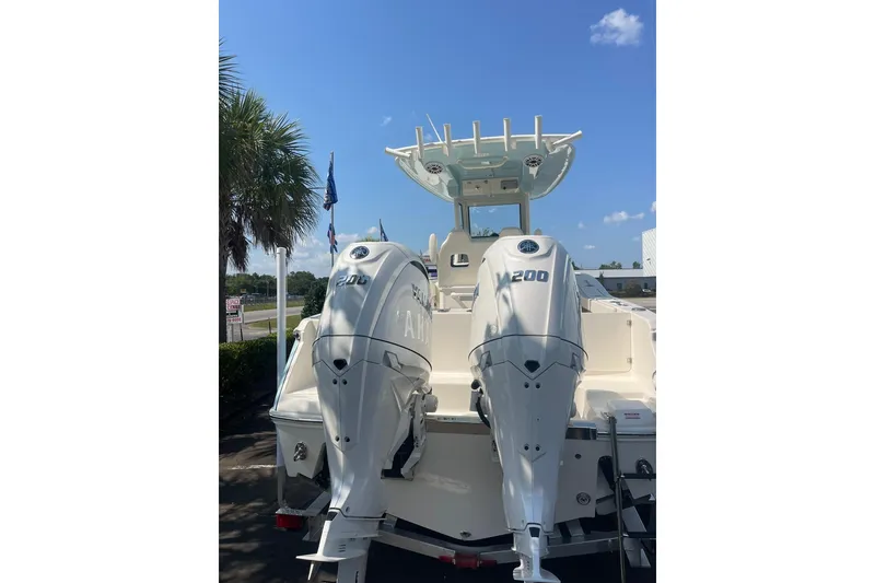 Slide: The Image of 2026 Pioneer 250 Pelagic boat with dual 200 horsepower engines, parked under a clear blue sky. - 2