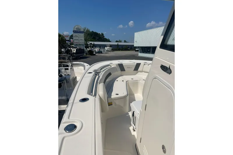 Slide: The Image of 2026 Pioneer 250 Pelagic boat interior with seating, docked at a marina under clear skies. - 7