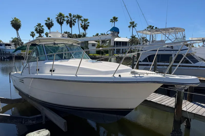 The Image of 2001 Pursuit 3000 Express boat docked in a sunny marina setting. - 0