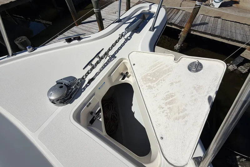Slide: The Image of 2001 Pursuit 3000 Express boat anchor locker with chain and winch at dock. - 12