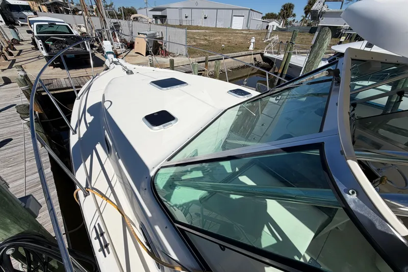 Slide: The Image of 2001 Pursuit 3000 Express boat docked, showcasing sleek design and spacious deck. - 13