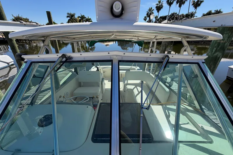 Slide: The Image of 2001 Pursuit 3000 Express boat interior with clear glass windows and white seating. - 14