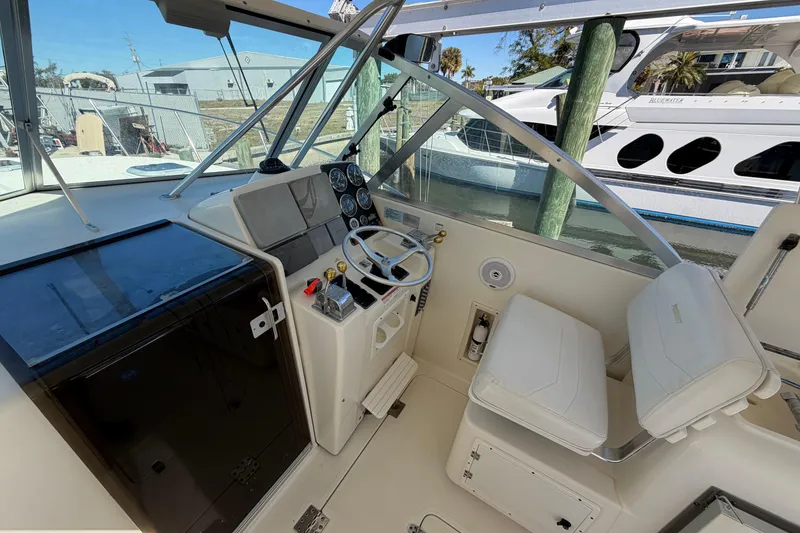 Slide: The Image of 2001 Pursuit 3000 Express boat cockpit with steering wheel and control panel. - 19