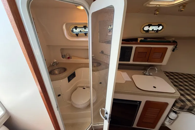 Slide: The Image of Interior of 2001 Pursuit 3000 Express boat showing bathroom and kitchenette. - 20