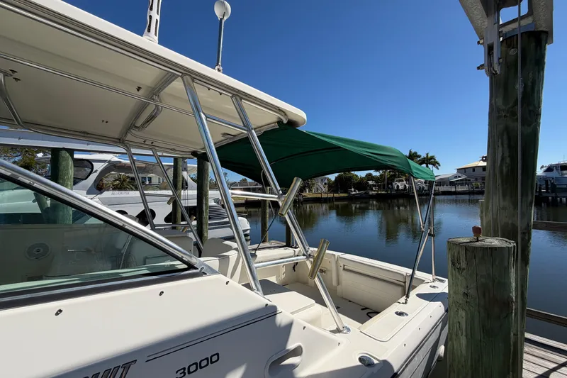 Slide: The Image of 2001 Pursuit 3000 Express boat docked by calm waters under clear blue sky. - 4