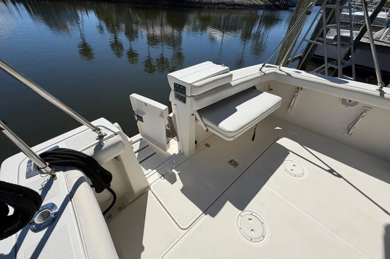 Slide: The Image of 2001 Pursuit 3000 Express boat deck with seating, docked by calm water. - 6