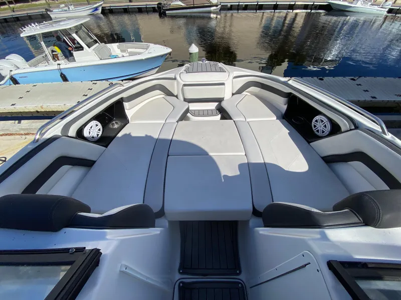 Slide: The Image of 2018 Yamaha Boats 242 Limited S interior, featuring spacious seating and sleek design at the dock. - 10