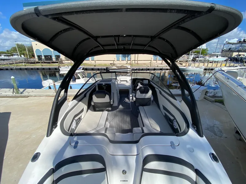 Slide: The Image of 2018 Yamaha Boats 242 Limited S with canopy, docked at marina. - 12