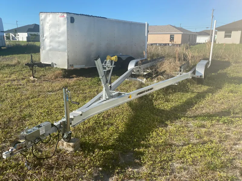 Slide: The Image of Boat trailer for 2018 Yamaha Boats 242 Limited S on grassy lot. - 18