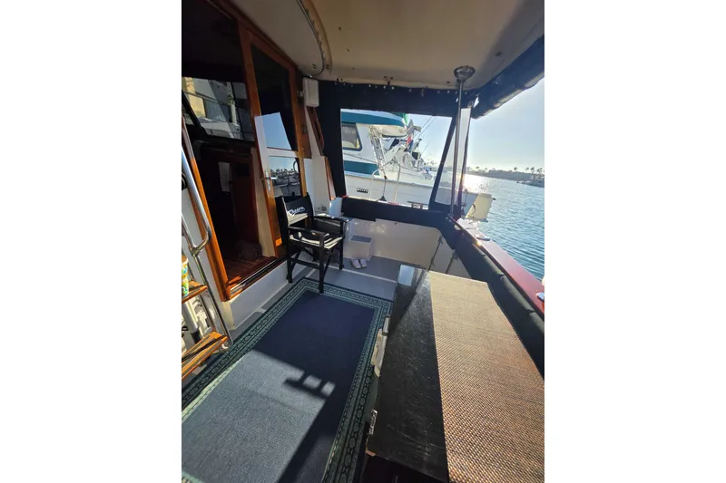 Slide: The Image of 1986 Bayliner 3870 Motoryacht interior with seating, overlooking marina and water. - 10