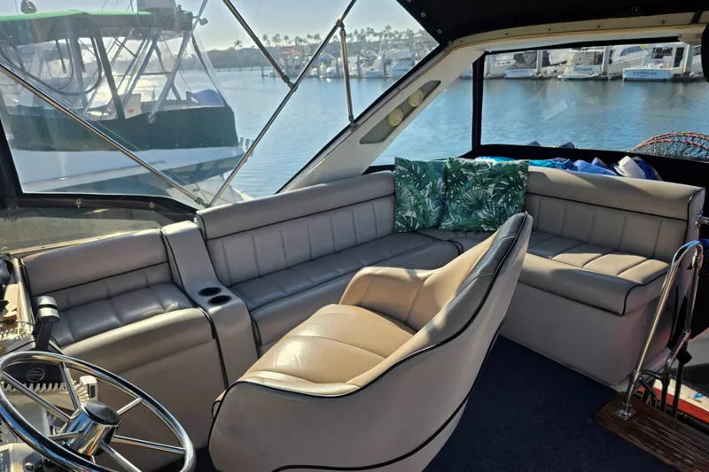 Slide: The Image of Interior of 1986 Bayliner 3870 Motoryacht with plush seating and scenic marina view. - 4