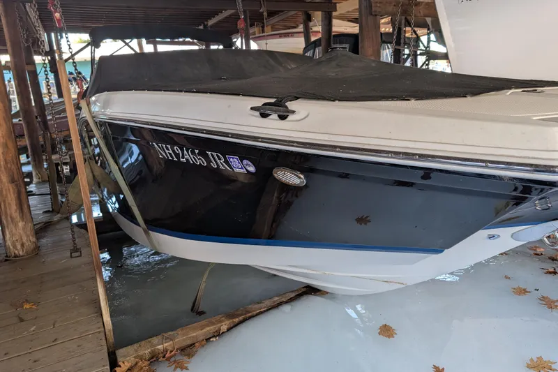 The Image of 2013 Cobalt 26SD boat docked, covered, with visible registration number NH2465 JR. - 0