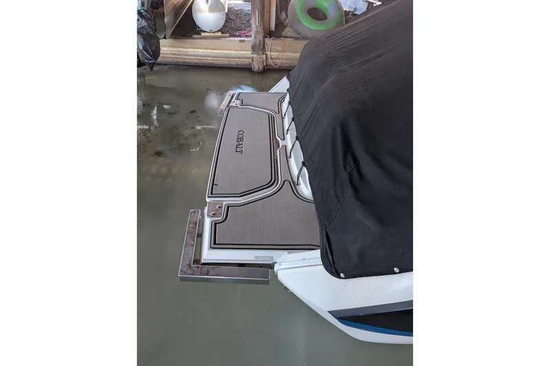 Slide: The Image of 2013 Cobalt 26SD boat with covered deck and swim platform in docked position. - 2