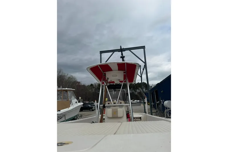 Slide: The Image of 2016 Carolina Skiff 218 DLV boat docked under cloudy skies. - 10