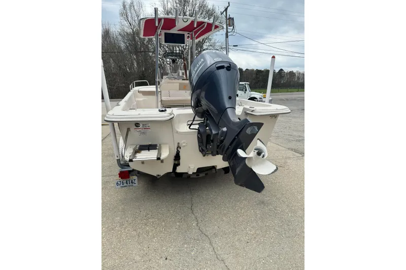 Slide: The Image of 2016 Carolina Skiff 218 DLV boat with outboard motor, parked on concrete. - 2