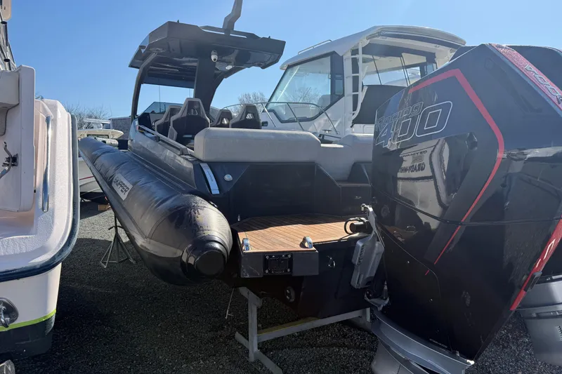 Slide: The Image of 2024 Skipper-BSK 38NC boat with powerful outboard engine, docked under clear blue sky. - 1