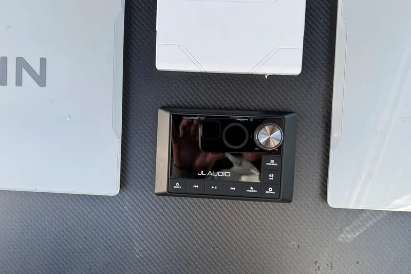Slide: The Image of JL Audio MediaMaster display on Skipper-BSK 38NC, 2024 model, with carbon fiber background. - 14