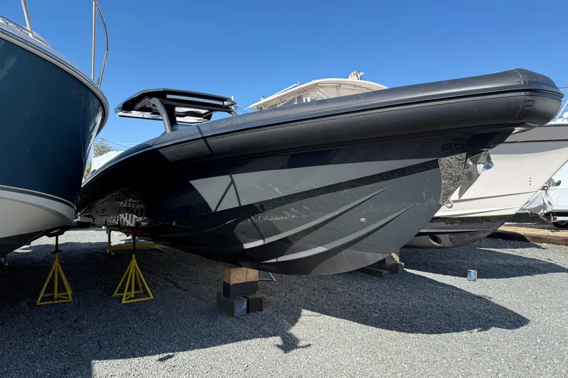 Slide: The Image of 2024 Skipper-BSK 38NC boat on stands, displayed outdoors under clear blue sky. - 2
