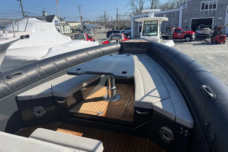 Slide: The Image of 2024 Skipper-BSK 38NC boat with cushioned seating and table, docked outdoors. - 3