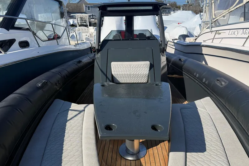 Slide: The Image of 2024 Skipper-BSK 38NC boat interior with seating and table, docked among other boats. - 6