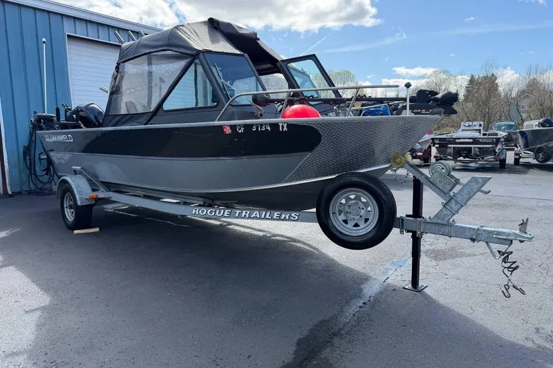 The Image of 2010 Alumaweld Blackhawk 202 boat on Rogue trailer, parked outdoors. - 1