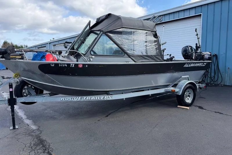 Slide: The Image of 2010 Alumaweld Blackhawk 202 boat on trailer, parked outside a blue building. - 5