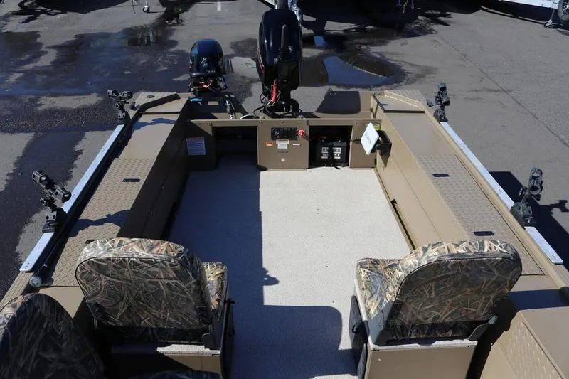 Slide: The Image of 2025 Smoker Craft Pro Sportsman 1866 boat interior with camo seats and motor. - 10