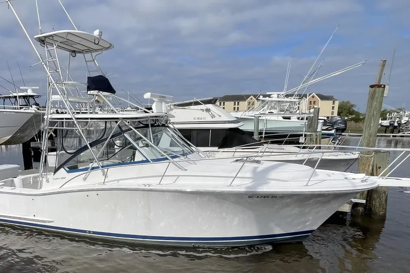 The Image of 2007 Luhrs 31 Open boat docked at marina under cloudy sky. - 0