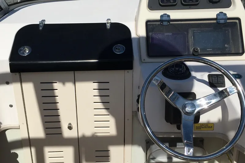 Slide: The Image of 2007 Grady-White Adventure 208 boat dashboard with steering wheel and navigation instruments. - 5